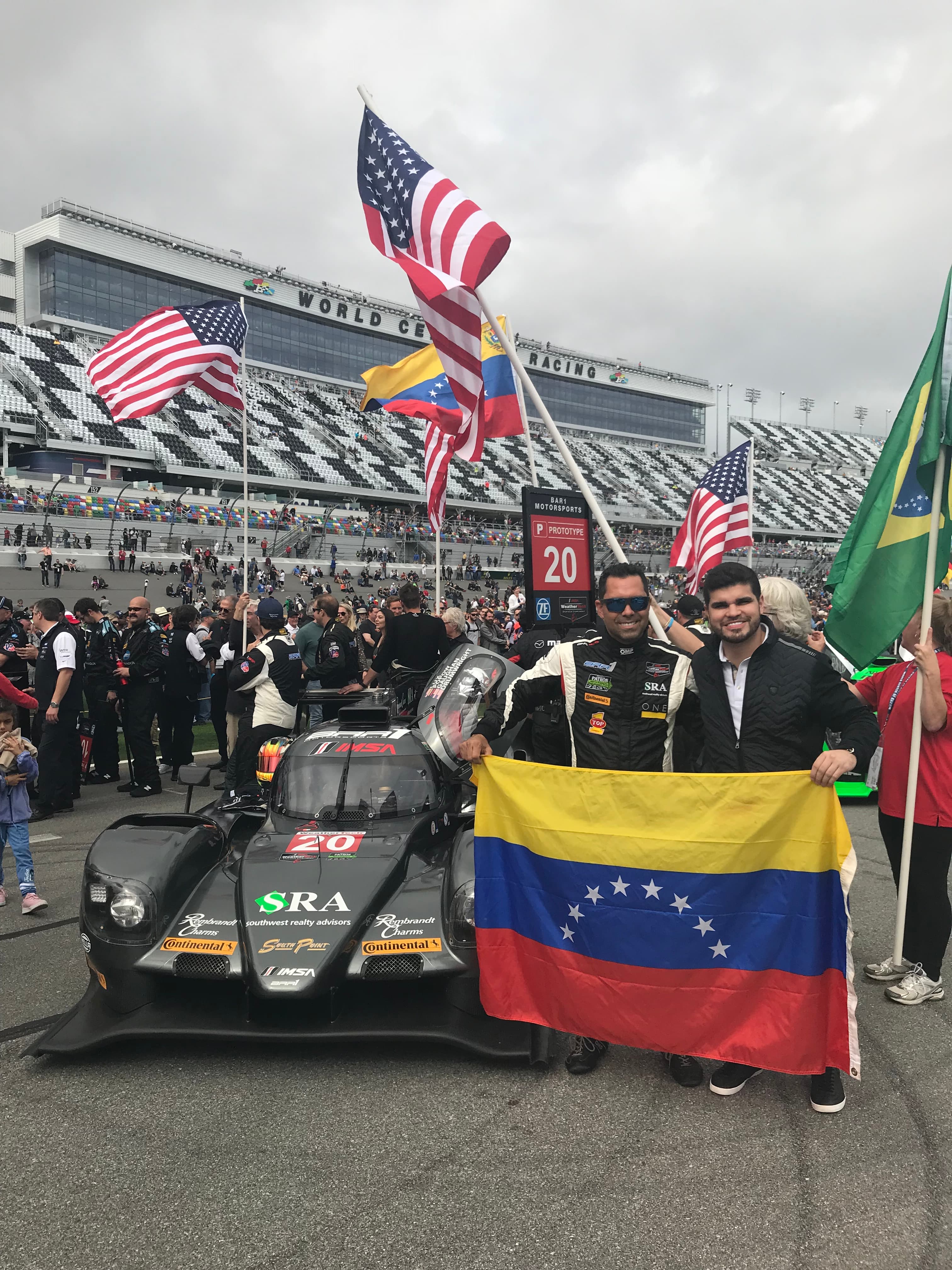 Harry en el pit lane del Daytona 24 junto al carro de carreras No. 20 con bandera venezolana